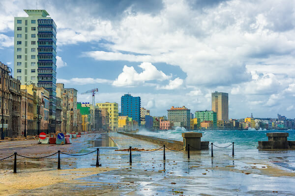 Havana during a hurricane with big waves crashing against the seaside wall and debris on the street