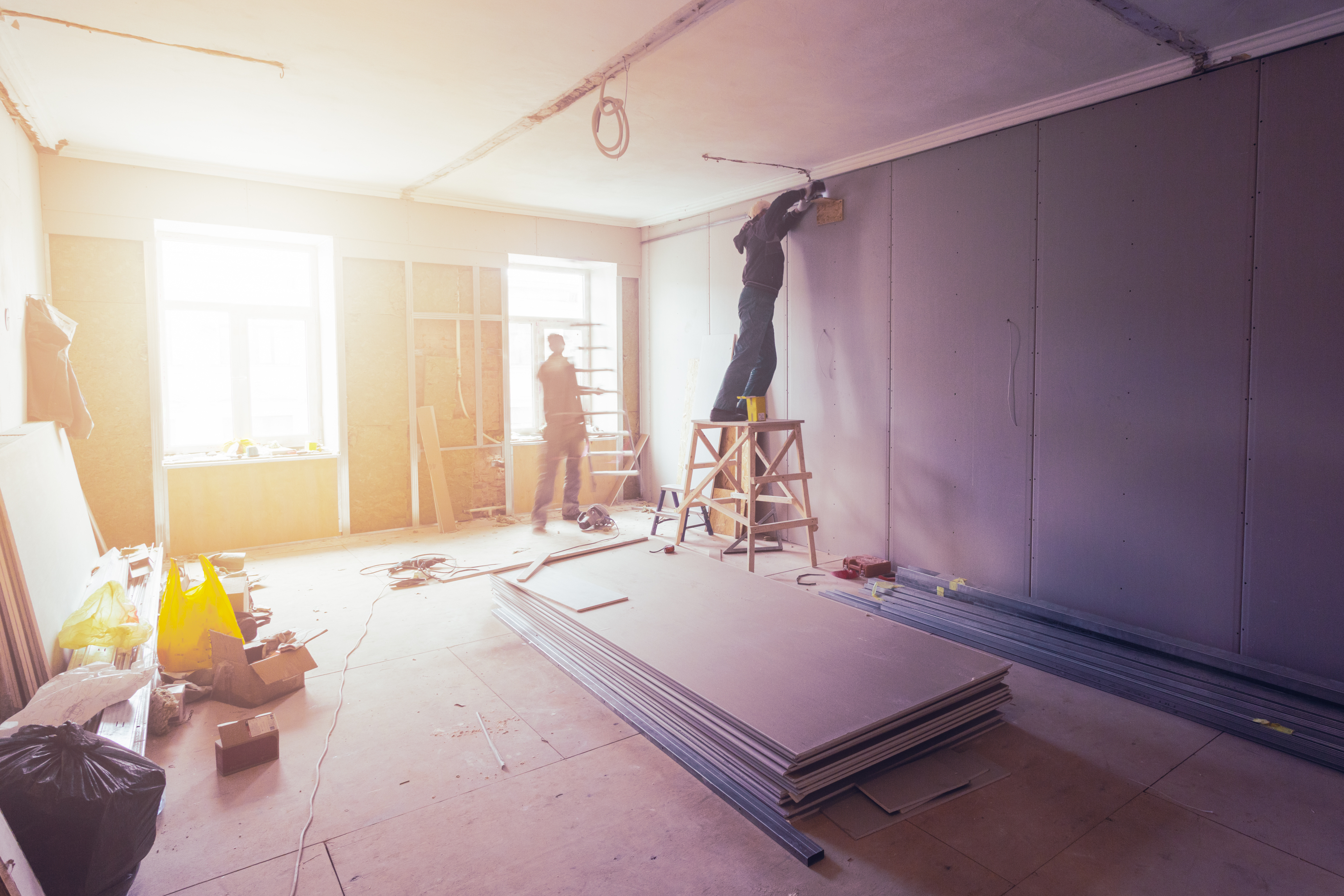 Workers are installing plasterboard (drywall) for gypsum walls in apartment is under construction, remodeling, renovation, extension, restoration and reconstruction